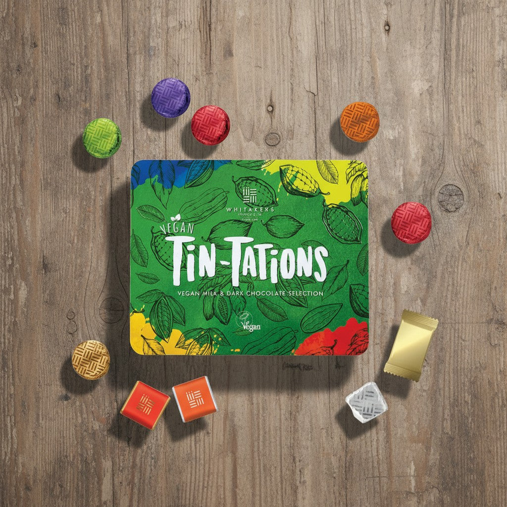 Vegan Tin-Tations chocolate selection on a wooden surface