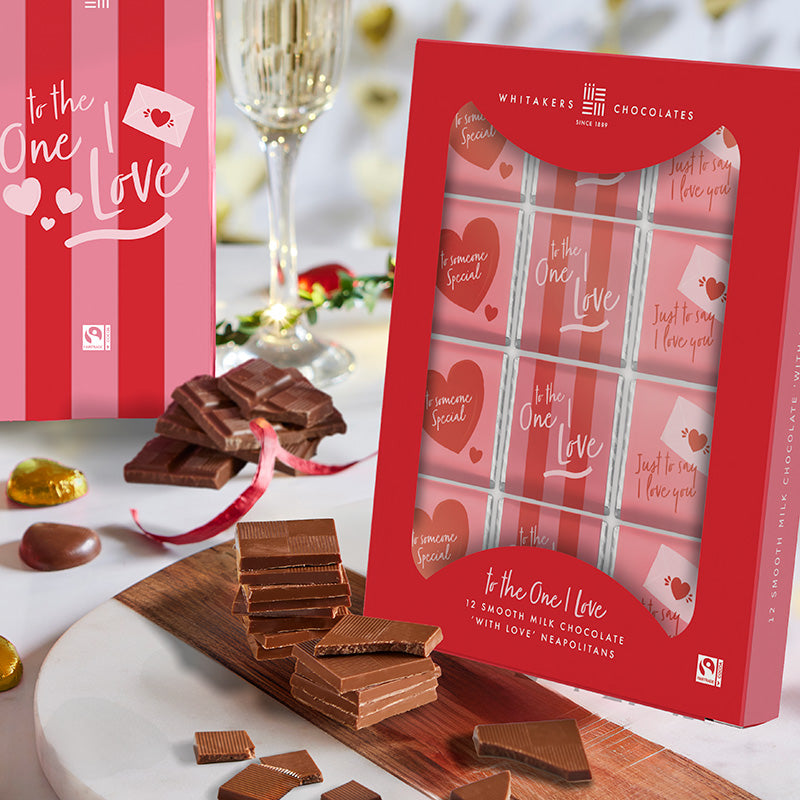 Whitaker's Chocolates 'To the One I Love' packaging with chocolate bars on a decorative table.