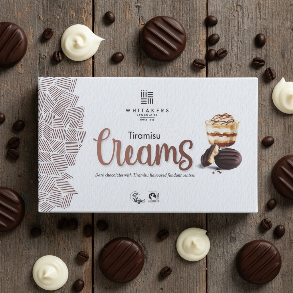 Whitaker's dark chocolate Tiramisu Creams packaging on a wooden surface with chocolate and coffee beans.