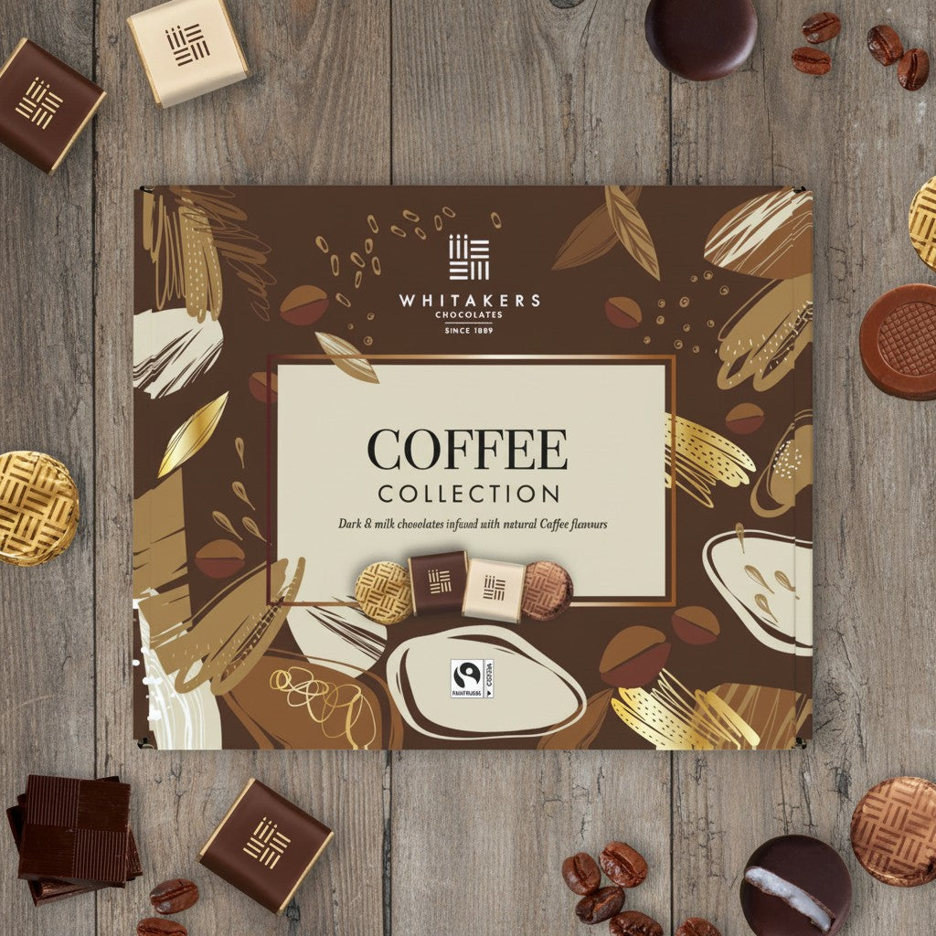 Whitaker's Coffee Collection chocolate box on a wooden surface with chocolate pieces around it.