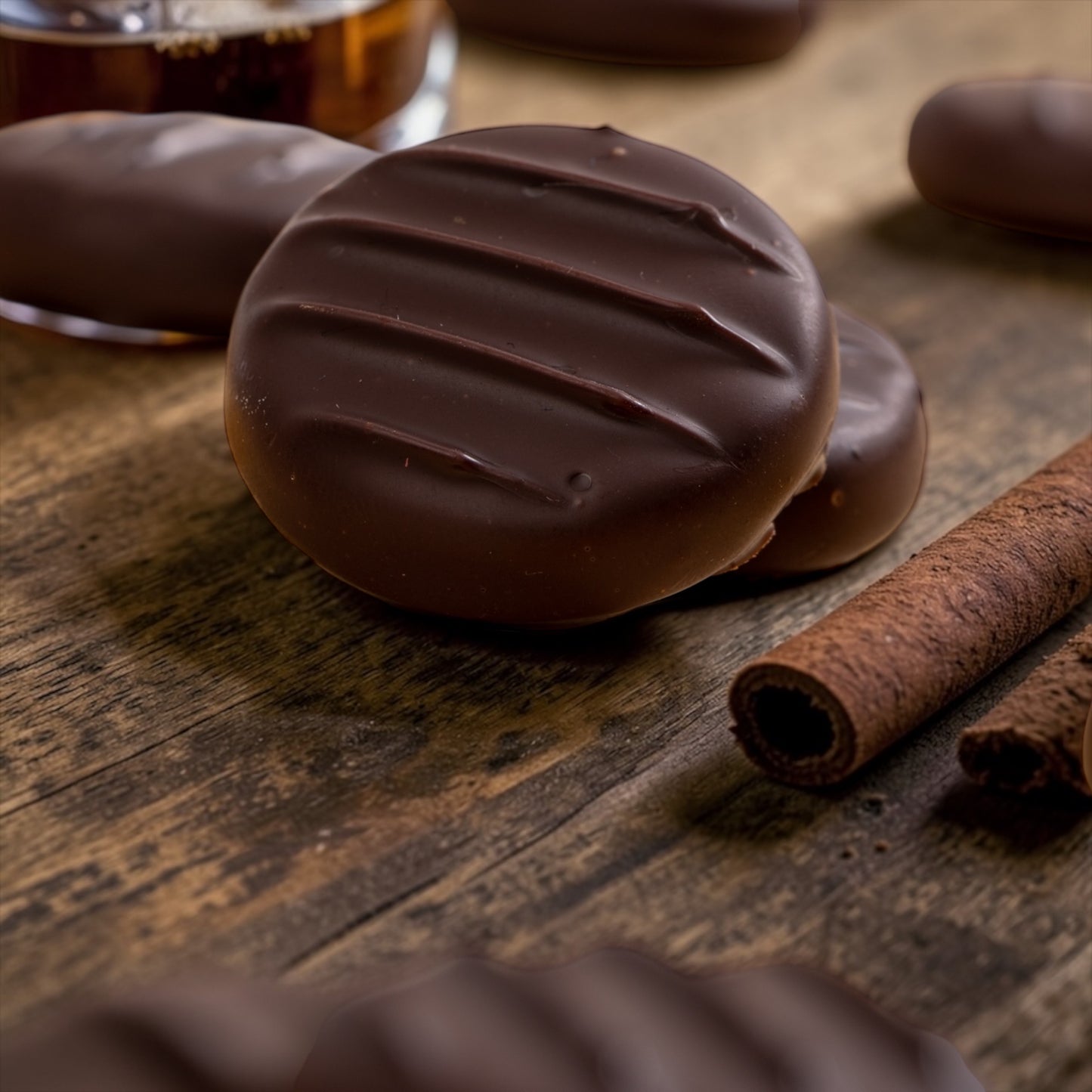 dark chocolate spiced rum creams, with cinnamon and a glass of rum on a wooden backdrop