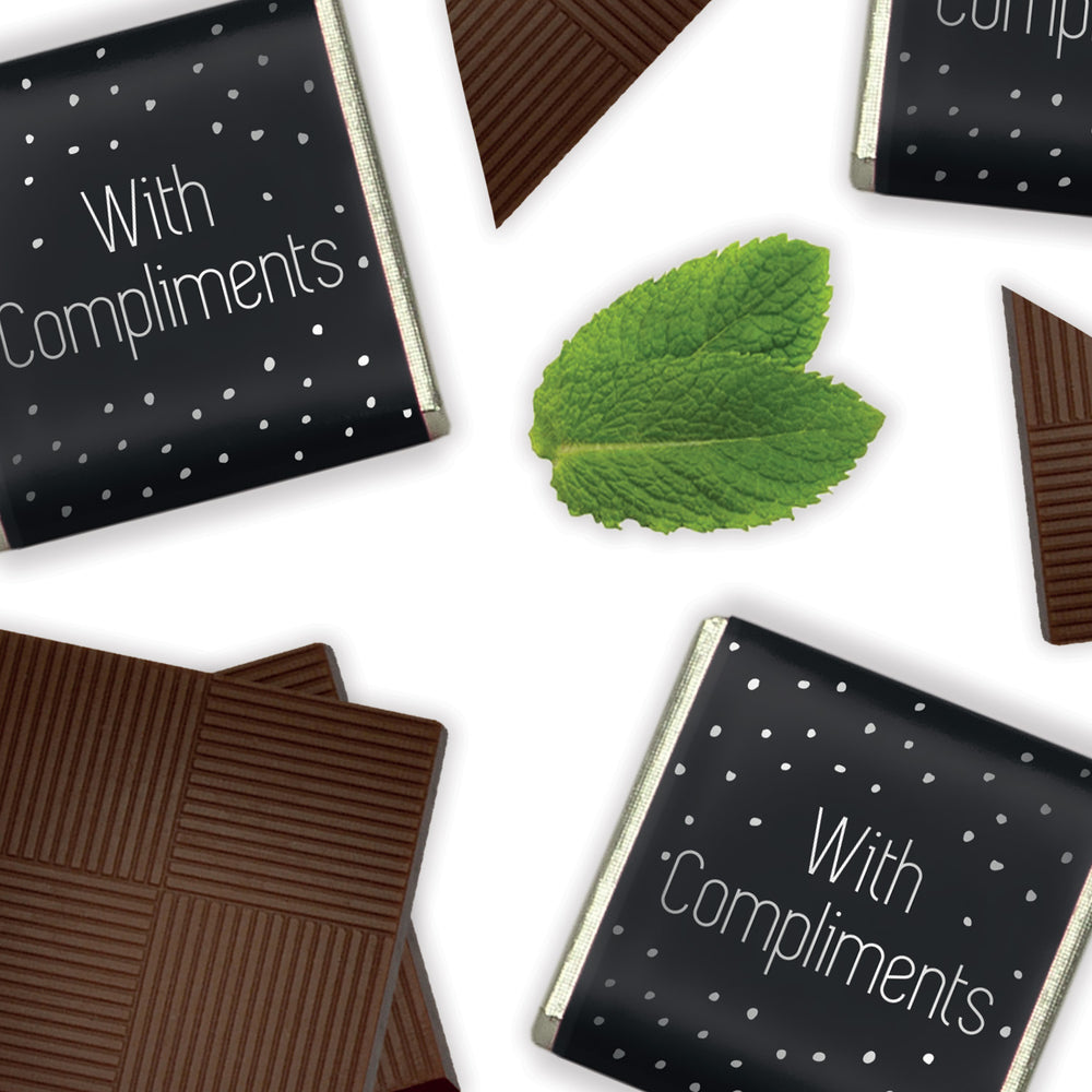 Dark Mint Chocolate Neapolitans, each piece a celebration of the rich, bold flavours of dark chocolate infused with the cool, refreshing essence of mint. Encased in elegant foil and paper wrappers that feature a sleek black background with 'with compliments' elegantly printed in silver. Packed in 2kg bulk catering boxes