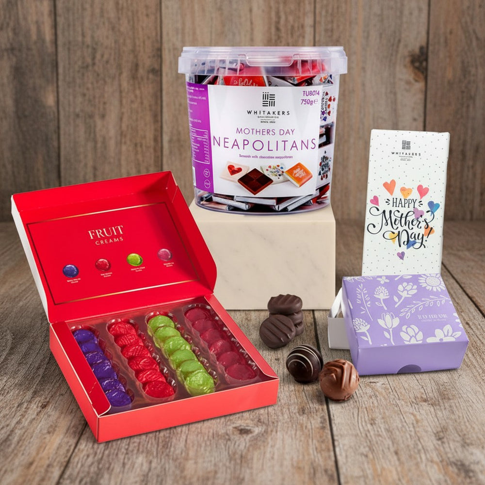 Collection of Mother's Day gifts including a box of chocolates, Neapolitans, and a card on a white background.