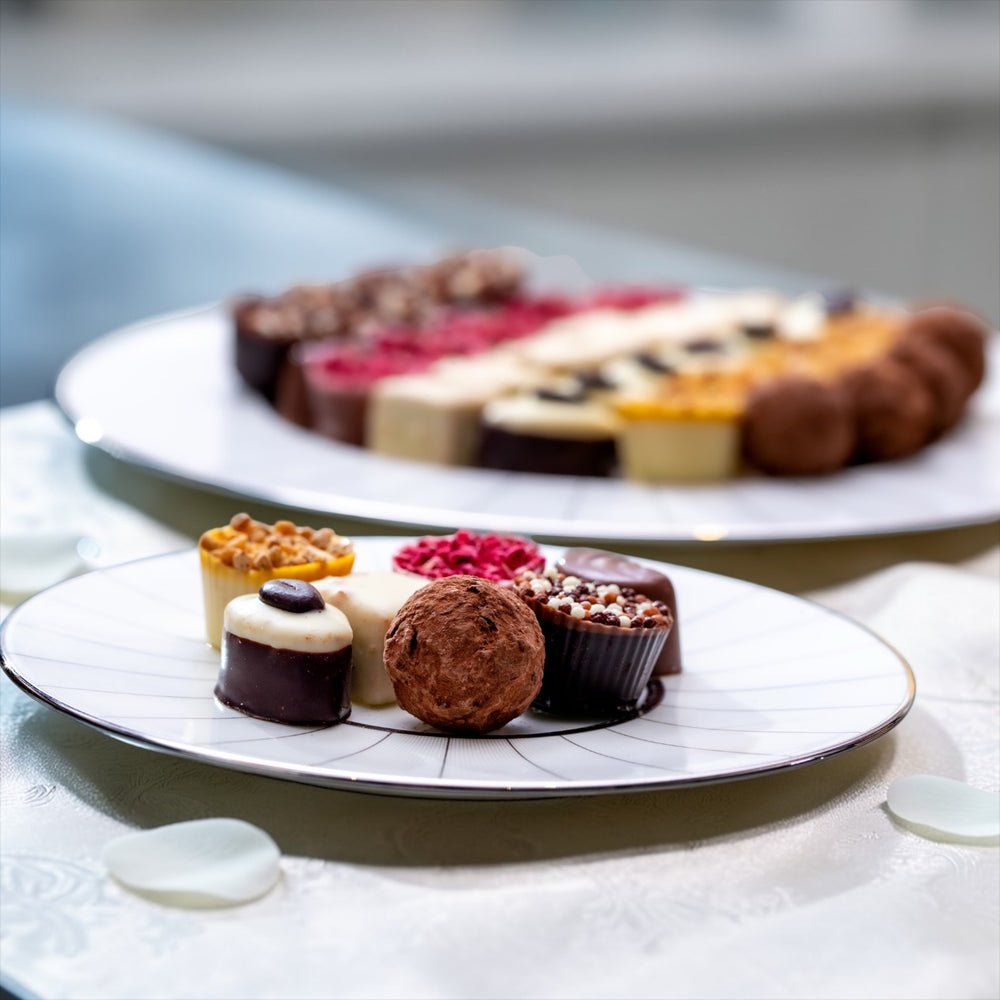 luxury chocolate truffles on a white and silver side plates on a white table cloth