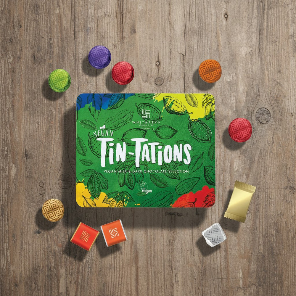 Vegan Tin-Tations chocolate selection on a wooden surface