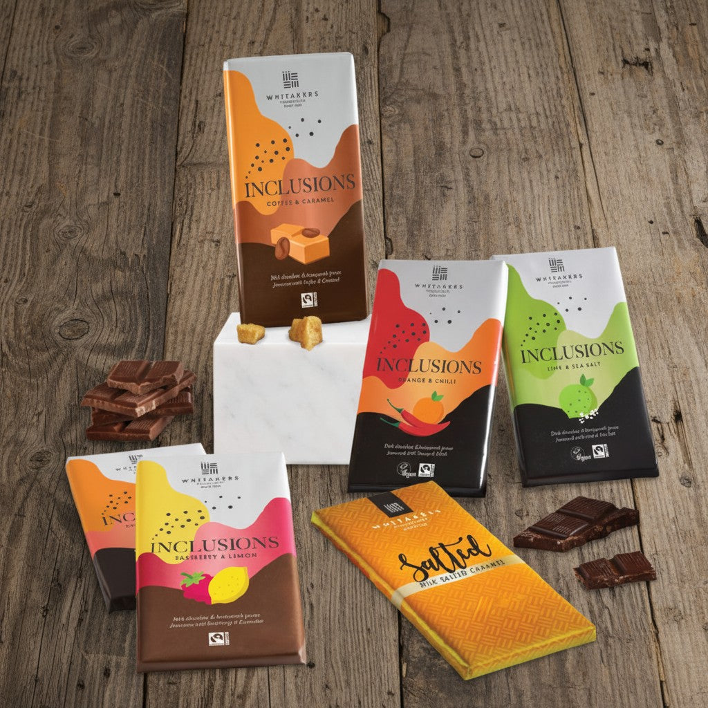 Whitakers Chocolates Fairtrade Assorted chocolate bars and packaging on a wooden surface