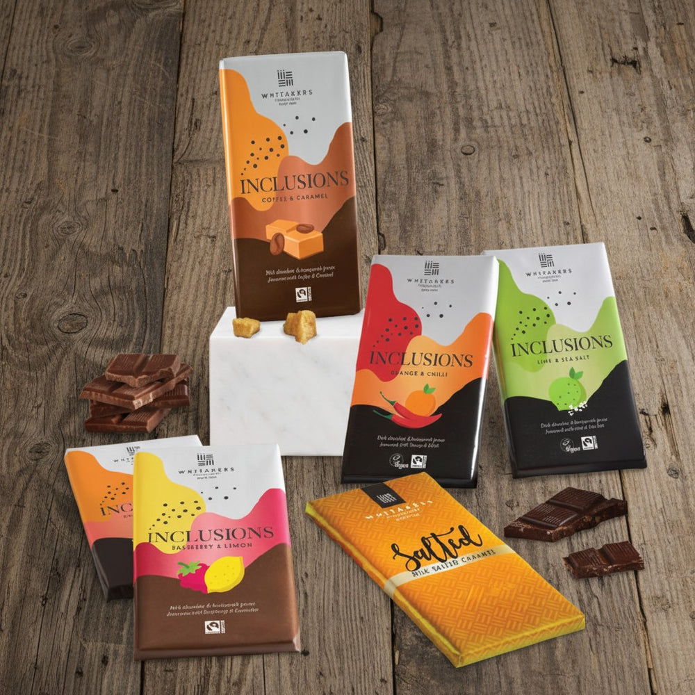 Whitakers Chocolates Fairtrade Assorted chocolate bars and packaging on a wooden surface