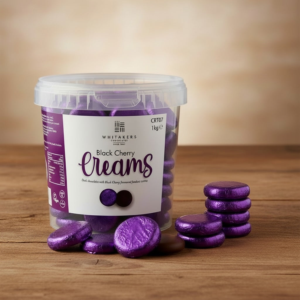 TUb of Whitakers purple foiled dark chocolate black cherry creams on a wooden surface