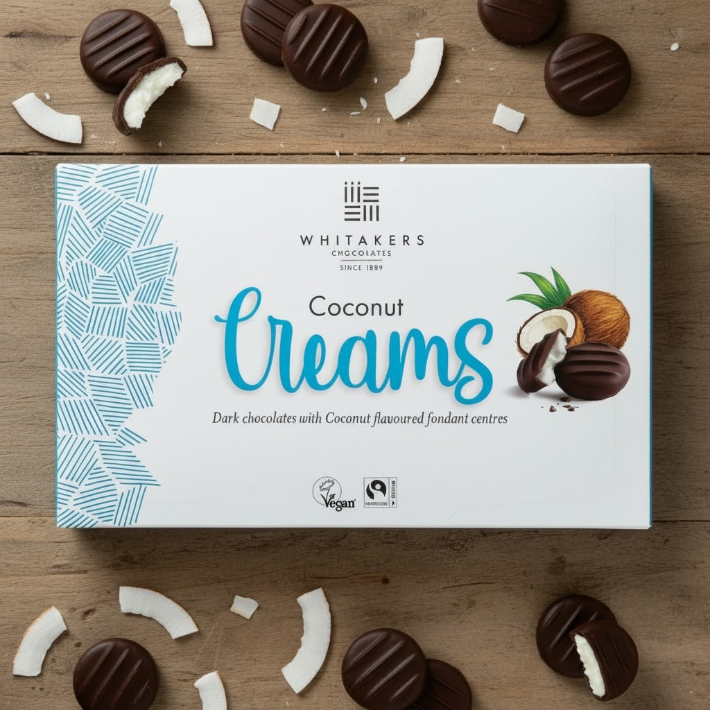 Whitaker's Dark Coconut Creams chocolate box on a wooden surface with coconut pieces.