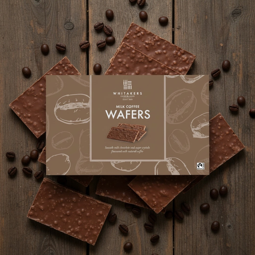 Box of Whitakers milk chocolate coffee wafers on a wooden background with wafers and cocoa beans